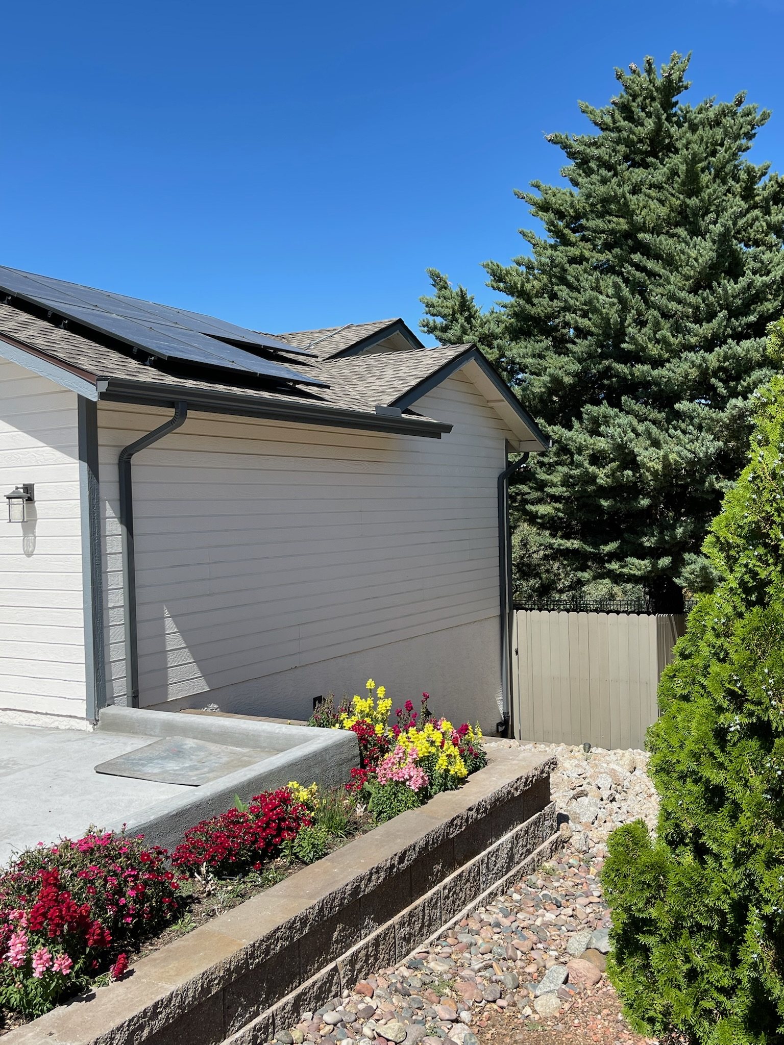 Roofline gutter and downspout beside a landscaped walkway